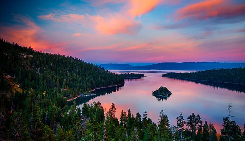 Rocky shoreline with turquoise waters and tall pine trees along Lake Tahoe in Tahoe Vista, CA.