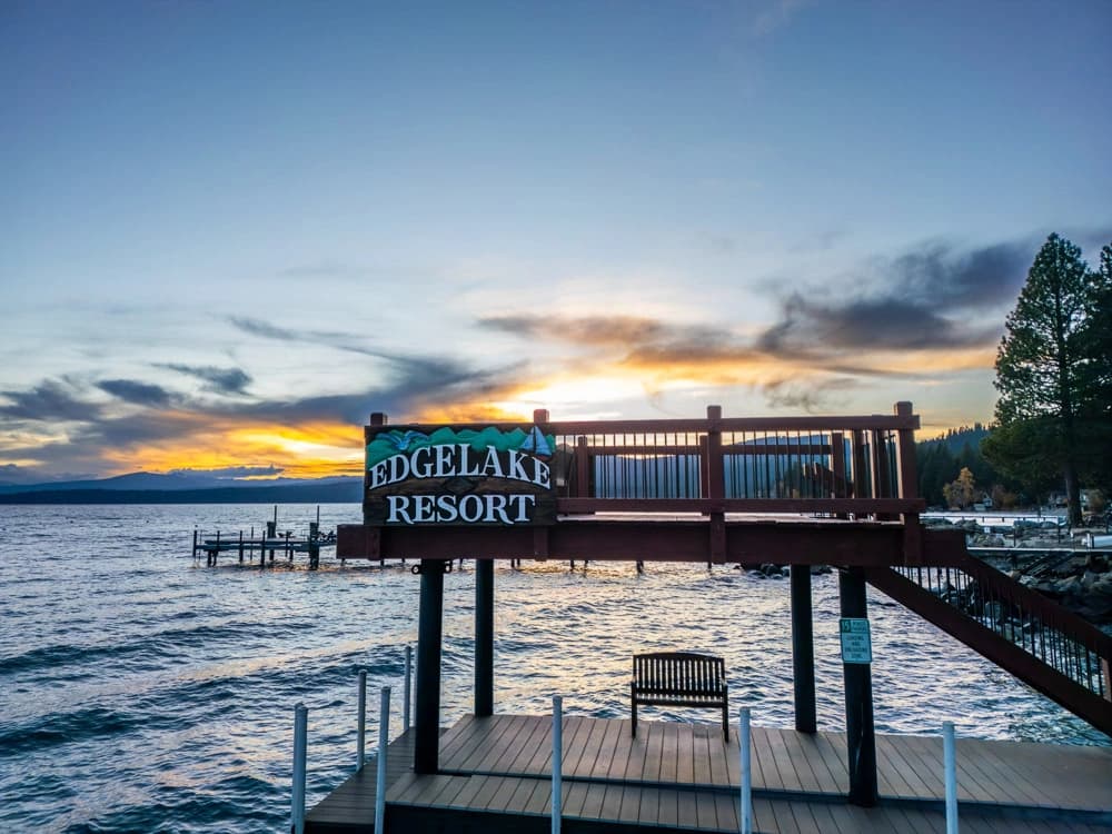 Edgelake Resort pier sign at sunset with mountains and glowing clouds